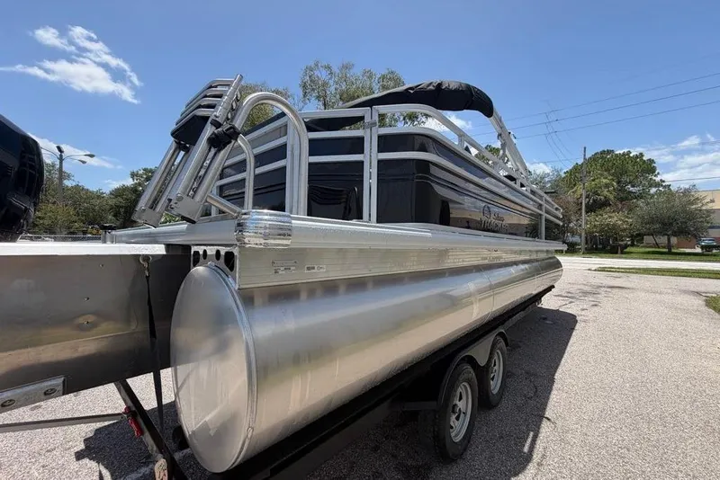 Slide: The Image of 2026 Sun Tracker Sportfish 24 XP3 pontoon boat on trailer, sunny day. - 9