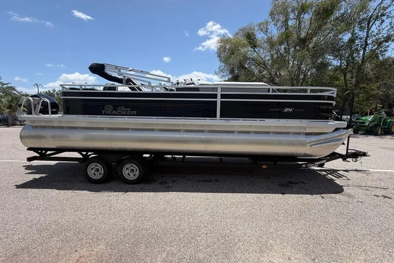 Slide: The Image of 2026 Sun Tracker Sportfish 24 XP3 pontoon boat on trailer, parked outdoors. - 8