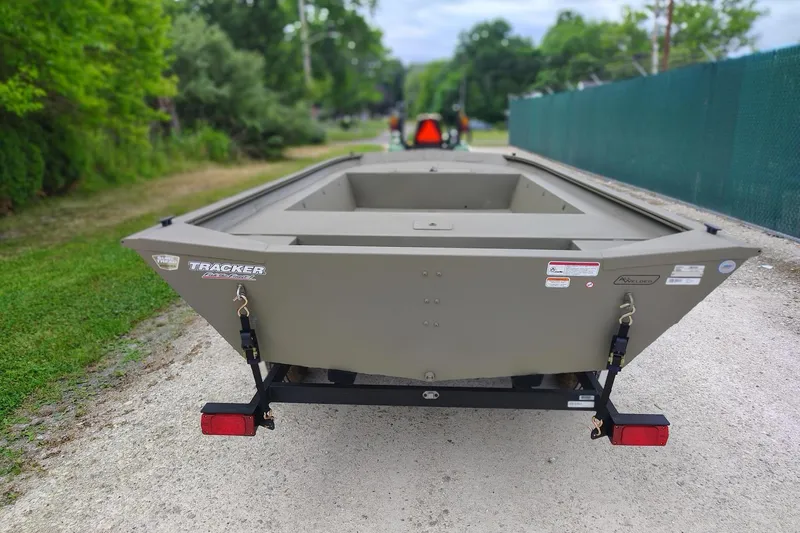 Slide: The Image of 2026 Tracker Grizzly 1754 Utility boat on trailer, parked on gravel path. - 3