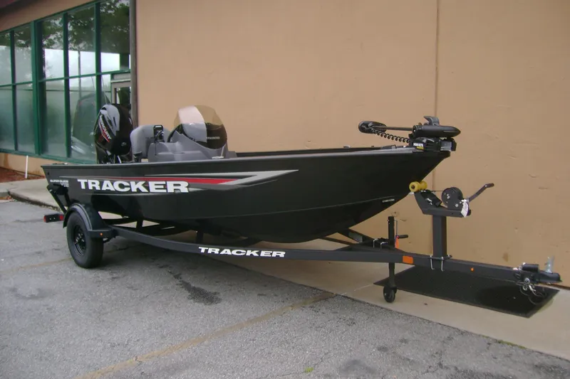 Slide: The Image of 2026 Tracker Super Guide V-16 SC fishing boat on trailer, parked outdoors. - 2