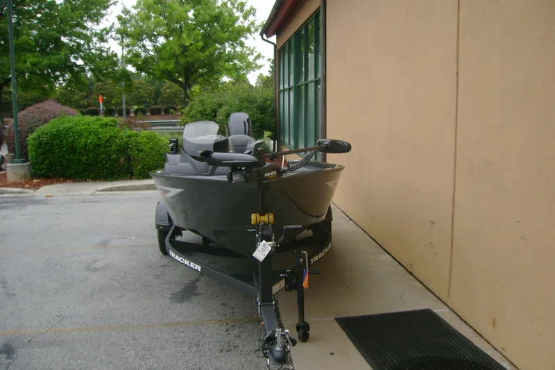 Slide: The Image of 2026 Tracker Super Guide V-16 SC boat parked beside a building. - 6