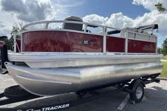 The Image of 2026 Sun Tracker Bass Buggy 16 XL Select pontoon boat on trailer, under a partly cloudy sky. - 0
