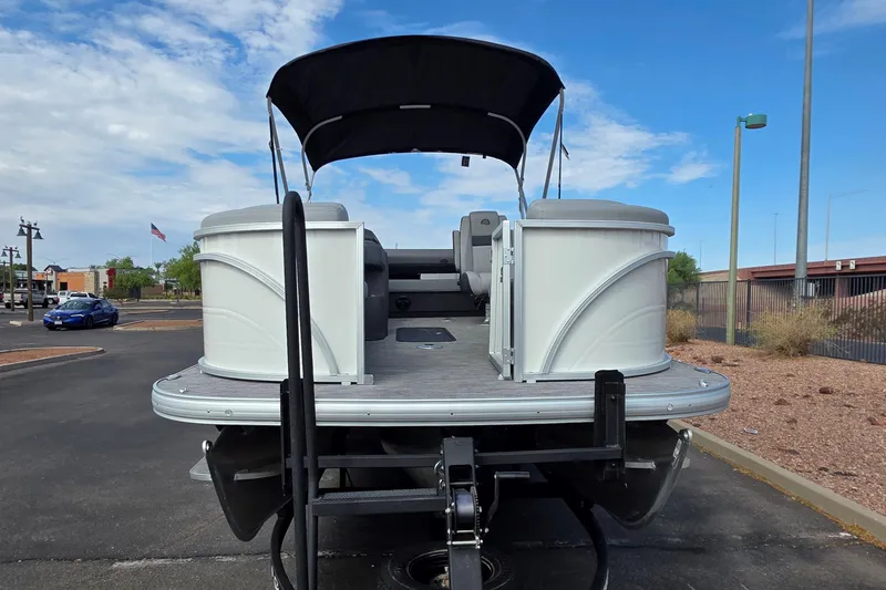 Slide: The Image of 2026 Sun Tracker Party Barge 22 RF XP3 pontoon boat, rear view, parked outdoors. - 2