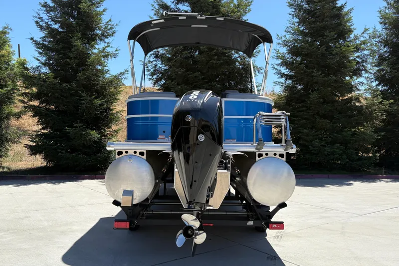 Slide: The Image of 2026 Sun Tracker Party Barge 22 XP3 pontoon boat with outboard motor, parked outdoors. - 5