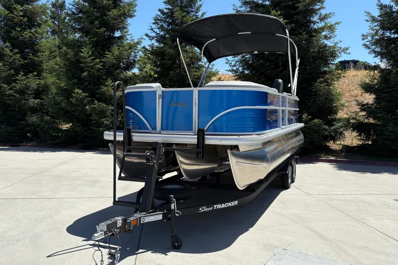 Slide: The Image of 2026 Sun Tracker Party Barge 22 XP3 pontoon boat on trailer, parked outdoors. - 7