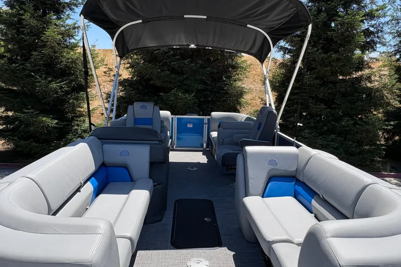 Slide: The Image of 2026 Sun Tracker Party Barge 22 XP3 with spacious seating and canopy, surrounded by trees. - 20