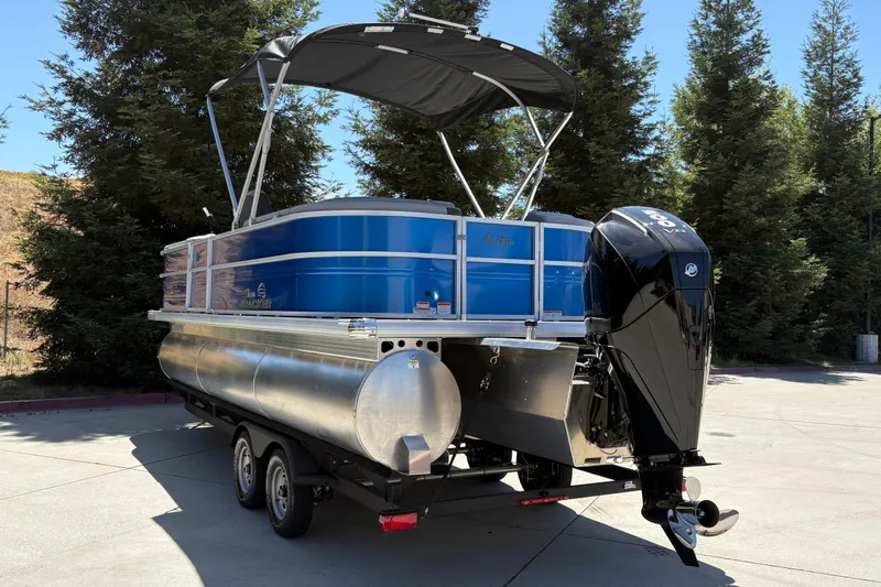 Slide: The Image of 2026 Sun Tracker Party Barge 22 XP3 pontoon boat on trailer, parked outdoors. - 4