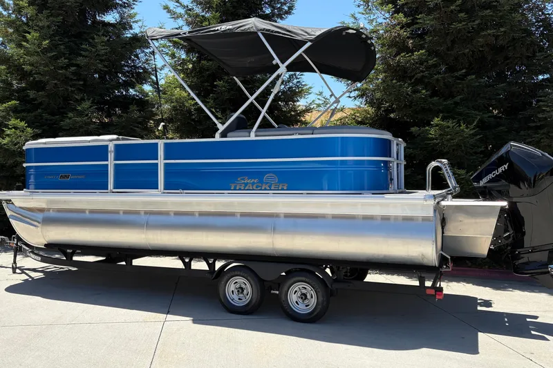 Slide: The Image of 2026 Sun Tracker Party Barge 22 XP3 pontoon boat on trailer, parked outdoors. - 9