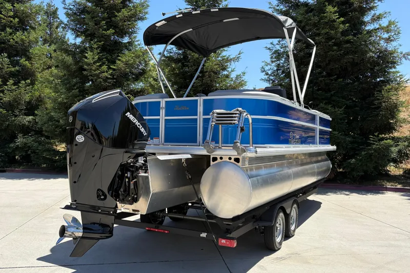 Slide: The Image of 2026 Sun Tracker Party Barge 22 XP3 pontoon boat with Mercury engine, parked outdoors. - 3