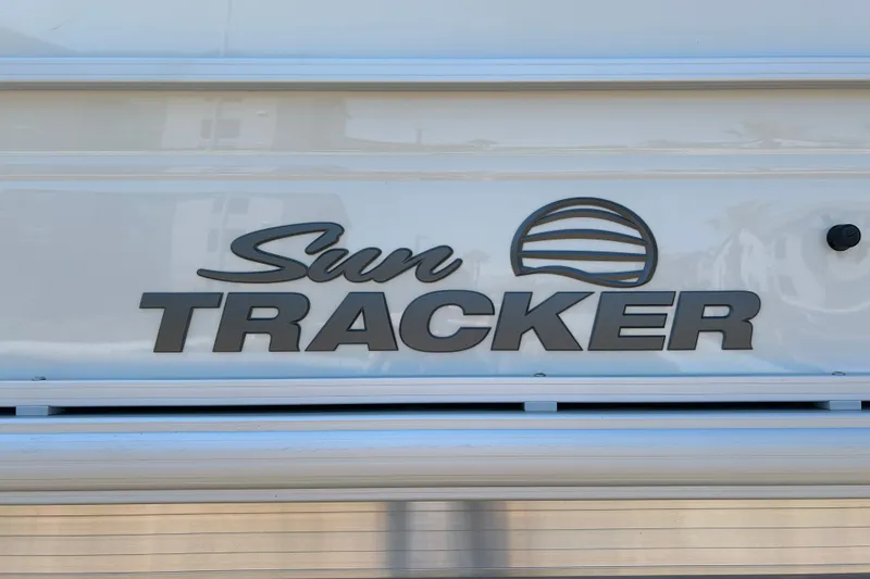 Slide: The Image of Sun Tracker Party Barge 18 DLX 2026 logo on a sleek white surface. - 25