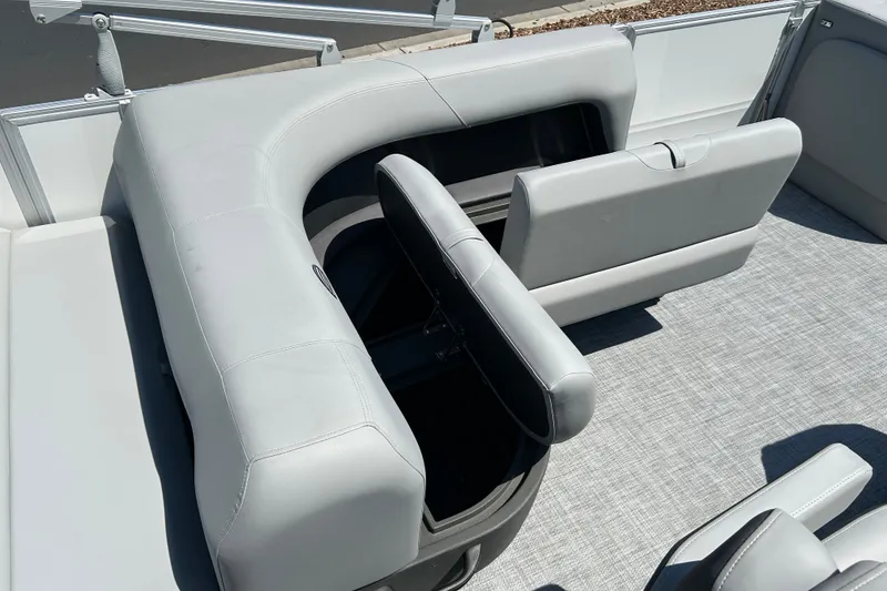 Slide: The Image of 2026 Sun Tracker Party Barge 18 DLX interior with gray seating and storage compartments. - 15