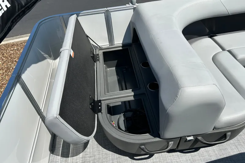 Slide: The Image of 2026 Sun Tracker Party Barge 18 DLX with open storage compartment and gray seating. - 16