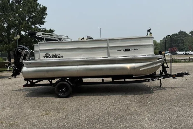 Slide: The Image of 2026 Sun Tracker Party Barge 18 DLX pontoon boat on trailer in parking lot. - 7
