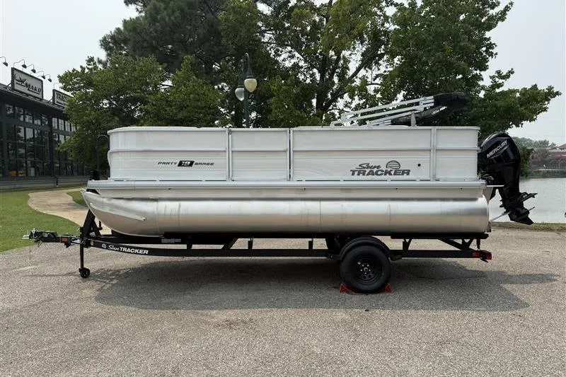 The Image of 2026 Sun Tracker Party Barge 18 DLX pontoon boat on trailer, parked outdoors. - 0