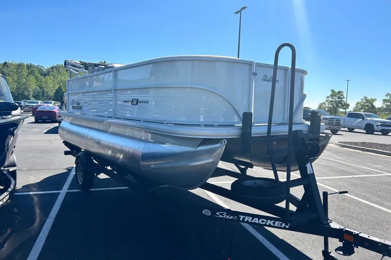 The Image of 2026 Sun Tracker Party Barge 18 DLX pontoon boat on trailer in parking lot. - 0