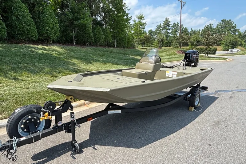 Slide: The Image of 2026 Tracker Grizzly 1648 SC boat on trailer, parked outdoors on a sunny day. - 2