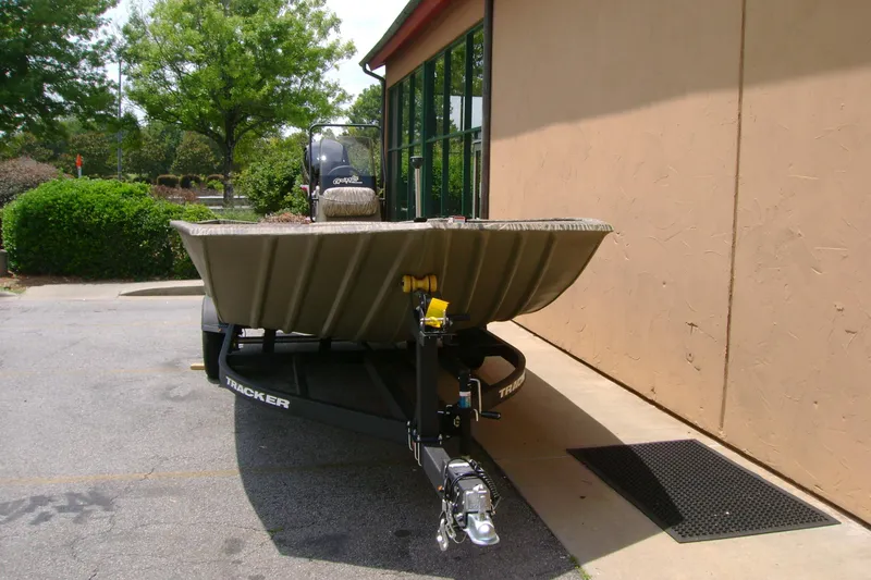 Slide: The Image of 2026 Tracker Grizzly 2072 CC boat on trailer, parked outdoors near a building. - 4