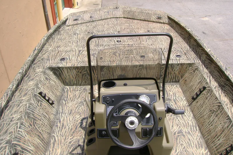 Slide: The Image of 2026 Tracker Grizzly 2072 CC boat interior with camouflage design and steering console. - 5
