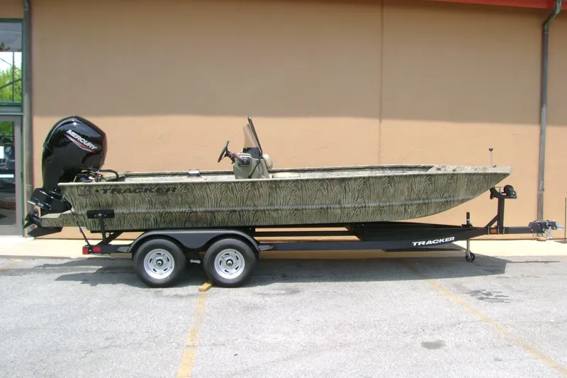 The Image of 2026 Tracker Grizzly 2072 CC boat on trailer, camo design, parked outdoors. - 0