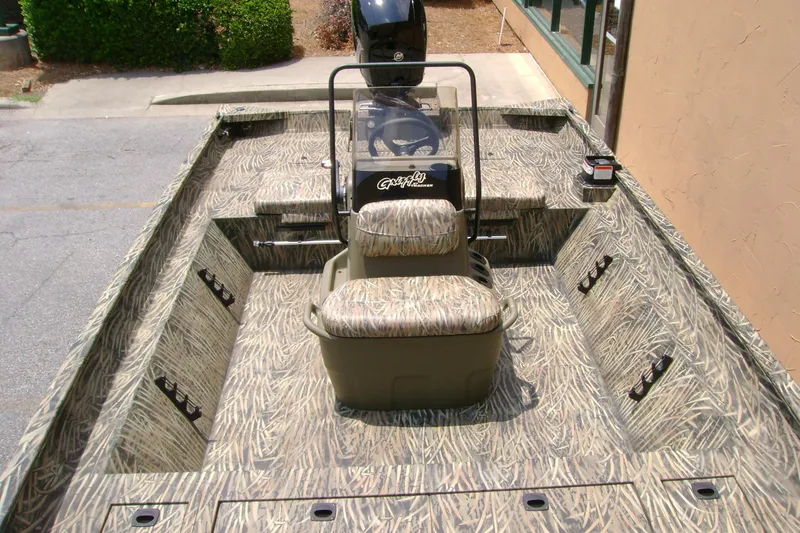 Slide: The Image of 2026 Tracker Grizzly 2072 CC boat with camouflage interior design, featuring central console seating. - 6