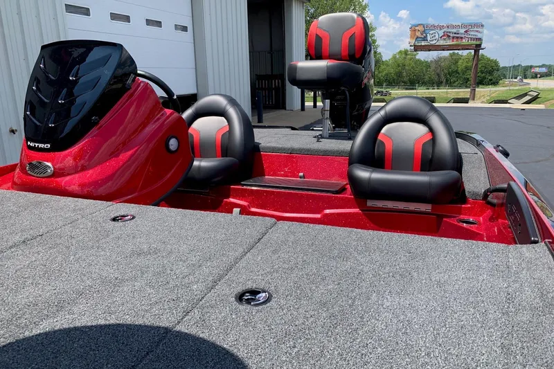 Slide: The Image of Red Nitro Z17 boat interior with black and red seats, 2026 model, parked outside a building. - 8