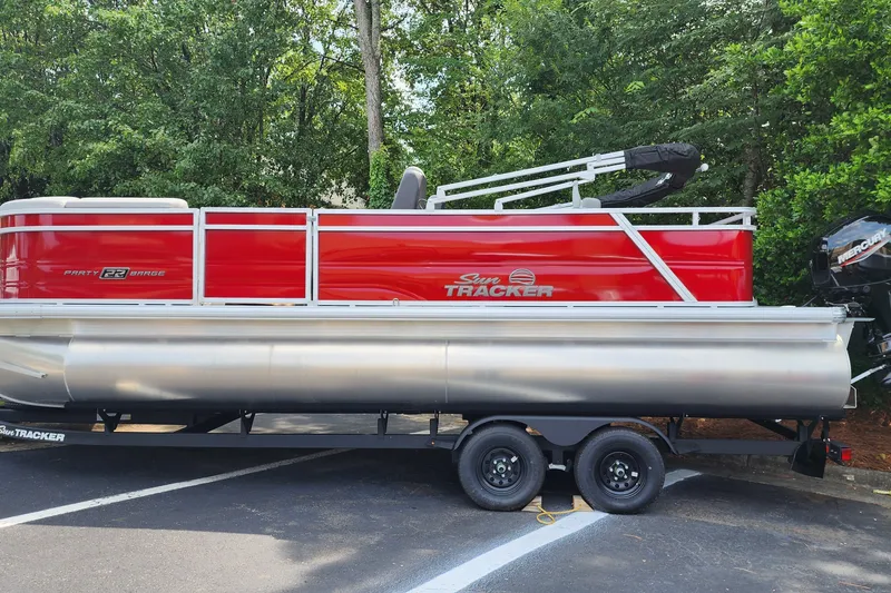 The Image of 2026 Sun Tracker Party Barge 22 RF DLX pontoon boat on trailer, parked outdoors. - 0