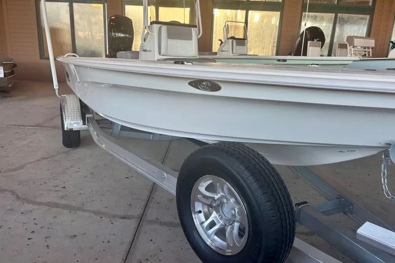 Slide: The Image of 2026 Mako 18 Pro Skiff boat on trailer, displayed indoors. - 1