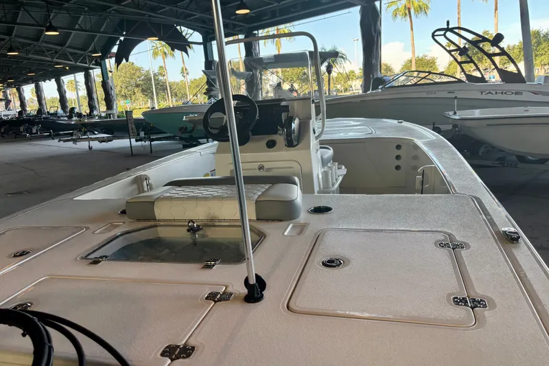 Slide: The Image of 2026 Mako 18 Pro Skiff boat interior under a covered marina with other boats. - 6