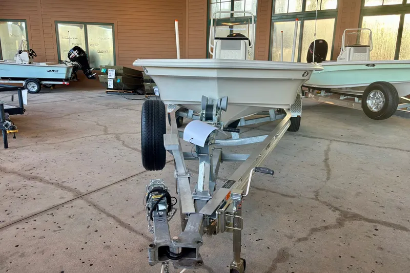 Slide: The Image of 2026 Mako 18 Pro Skiff boat on trailer in showroom setting. - 2