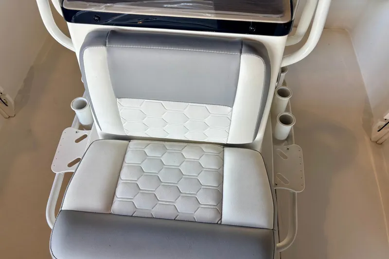Slide: The Image of 2026 Mako 18 Pro Skiff boat seat with hexagonal pattern and cup holders. - 10