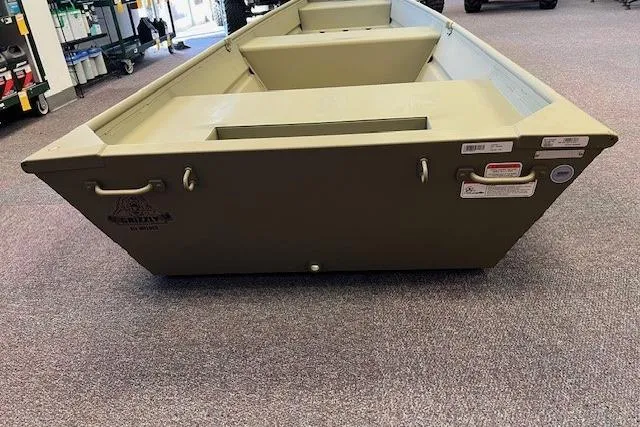 Slide: The Image of 2026 Tracker Grizzly 14 Jon boat displayed indoors on carpeted floor. - 4