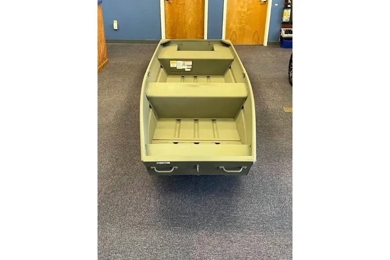 Slide: The Image of 2026 Tracker Grizzly 14 Jon boat displayed indoors on carpeted floor. - 2