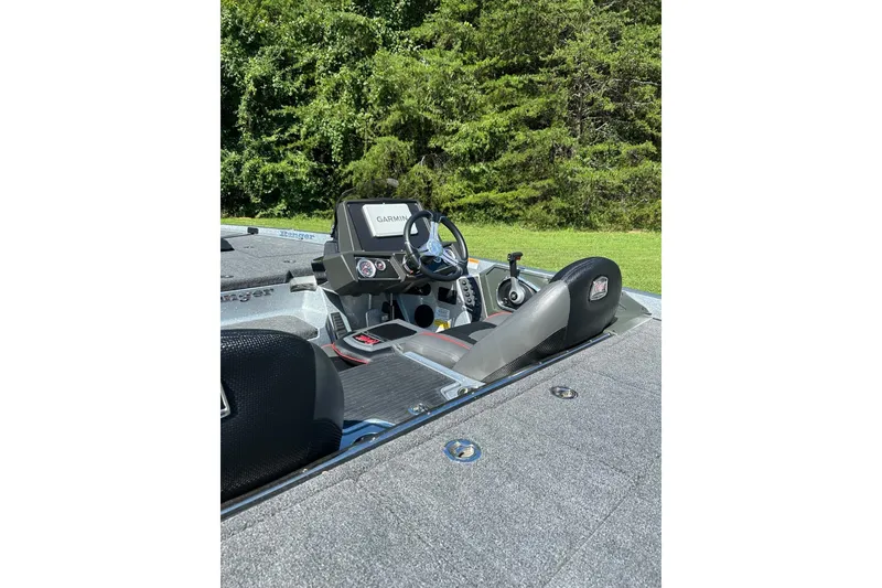 Slide: The Image of 2025 Ranger Z518 Cup-Equipped boat interior with Garmin navigation system, set against lush greenery. - 3