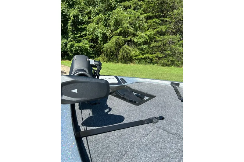 Slide: The Image of 2025 Ranger Z518 Cup-Equipped boat deck with trolling motor and lush green background. - 6