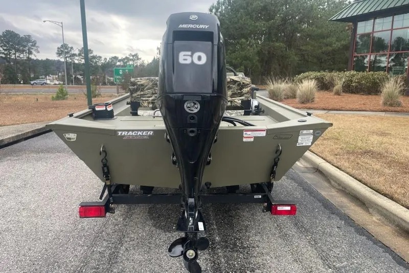 Slide: The Image of 2026 Tracker Grizzly 1754 SC boat with Mercury 60 engine, parked outdoors. - 4
