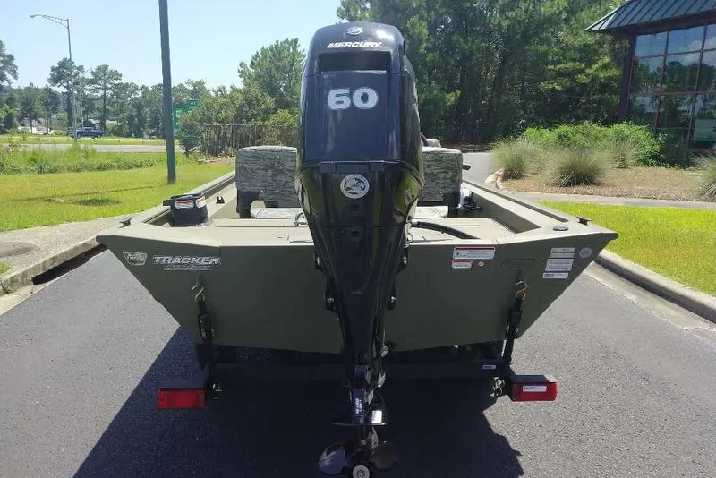 Slide: The Image of 2026 Tracker Grizzly 1754 SC boat with Mercury 60 engine, parked outdoors. - 8