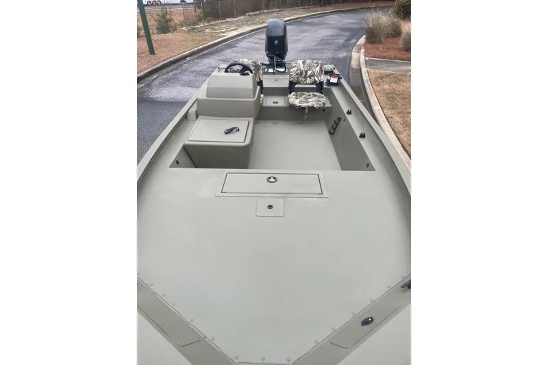 Slide: The Image of 2026 Tracker Grizzly 1754 SC boat with camouflage seating, parked on a paved road. - 3