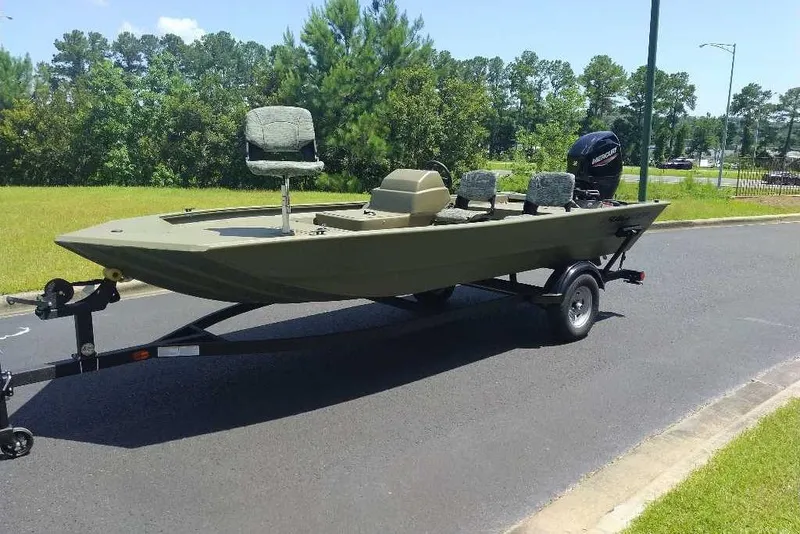 Slide: The Image of 2026 Tracker Grizzly 1754 SC boat on trailer, parked on a sunny road. - 10