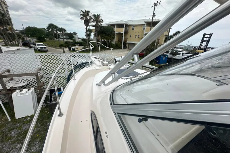 Slide: The Image of 2006 Grady-White Marlin 300 boat docked near coastal homes and palm trees. - 5