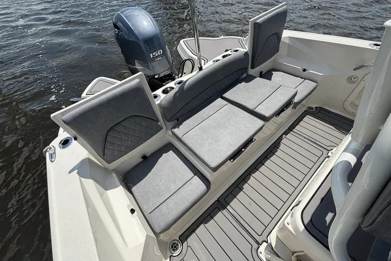Slide: The Image of 2021 Stingray 216 CC boat interior with cushioned seating and Yamaha 150 engine. - 11