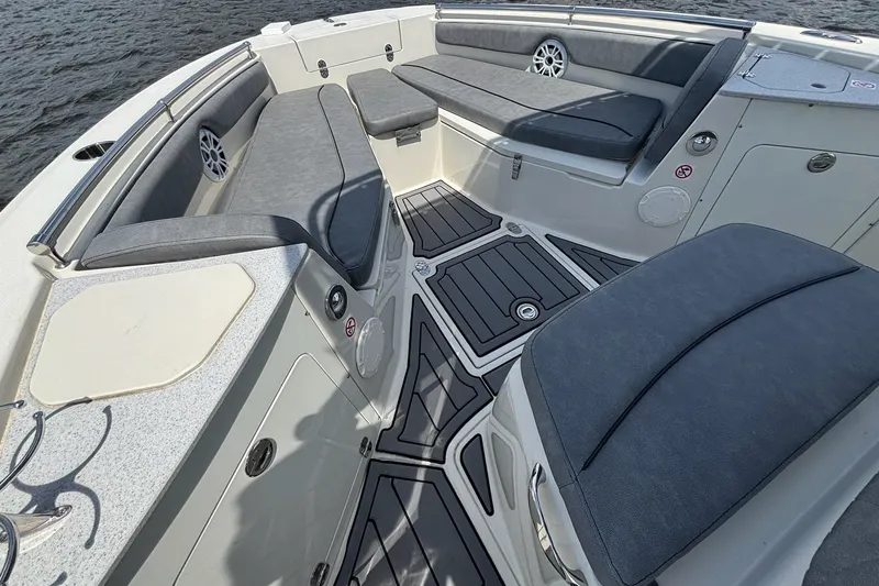 Slide: The Image of 2021 Stingray 216 CC boat interior with cushioned seating and sleek design on the water. - 17