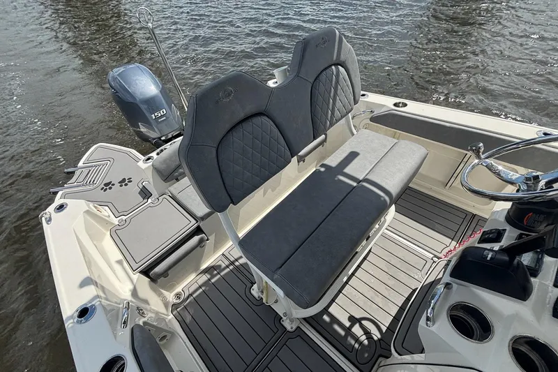 Slide: The Image of 2021 Stingray 216 CC boat interior with seating and outboard motor on water. - 20