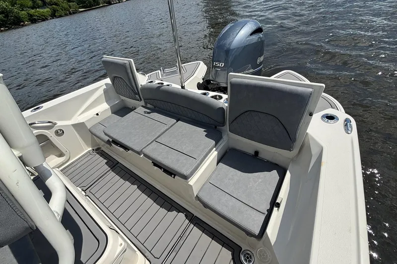 Slide: The Image of 2021 Stingray 216 CC boat interior with seating and Yamaha outboard motor on water. - 21