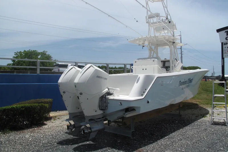 Slide: The Image of 2022 SeaVee 322Z boat with twin Mercury engines, parked on gravel. - 7