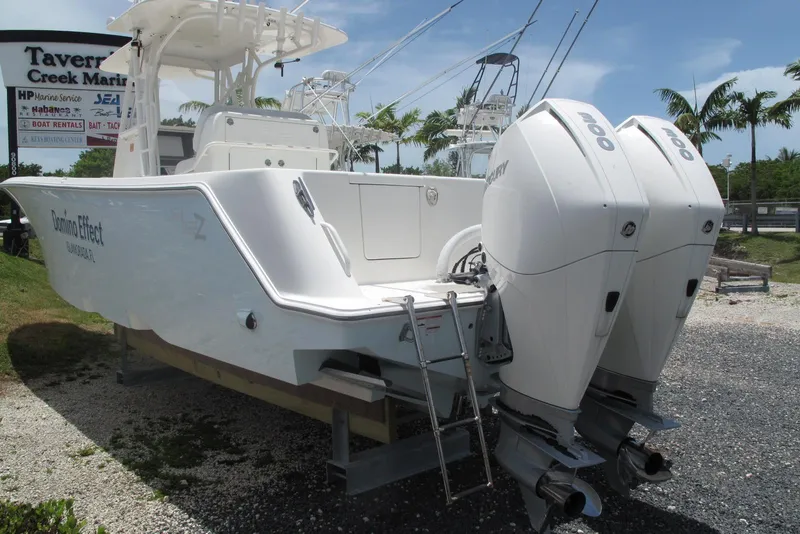Slide: The Image of 2022 SeaVee 322Z boat with twin Mercury engines at marina, surrounded by palm trees. - 5