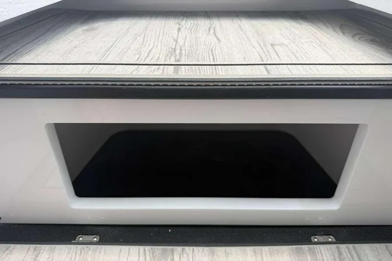Slide: The Image of Storage compartment of a 2026 Monterey Elite 30 OB boat with wood-textured flooring. - 29
