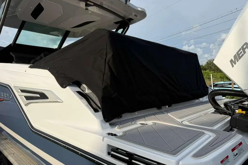Slide: The Image of 2026 Monterey Elite 30 OB boat with covered seating area and visible outboard motor. - 95