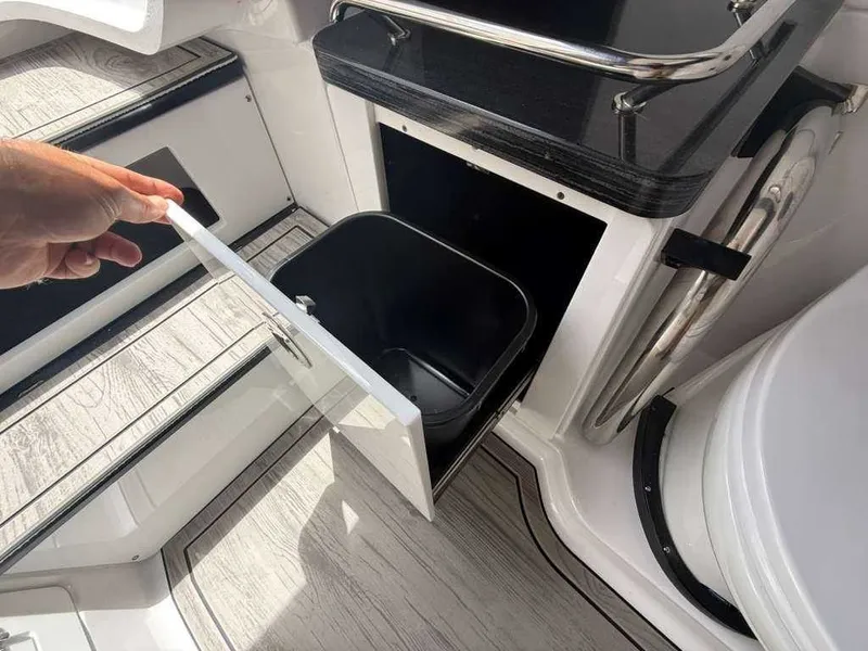 Slide: The Image of A trash bin inside a boat cabinet with an open door. - 19