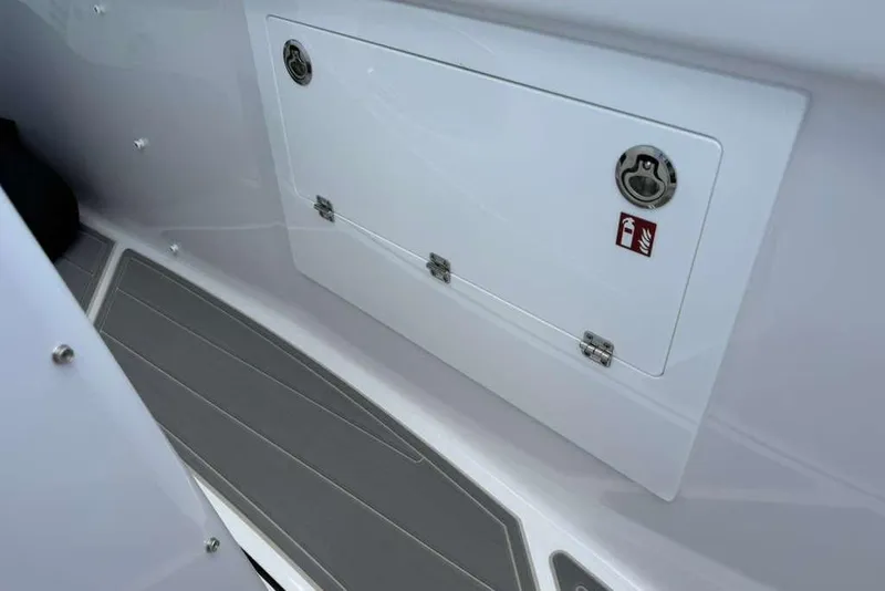 Slide: The Image of Storage compartment on 2026 Monterey Elite 30 OB boat with safety label. - 40