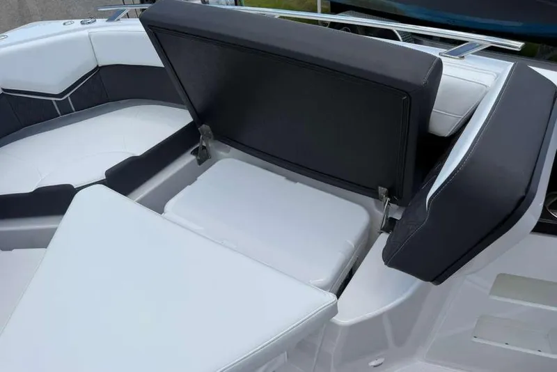 Slide: The Image of 2026 Monterey Elite 30 OB boat interior with open storage compartment and cushioned seating. - 45